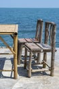 Bamboo table and wooden chairs in empty cafe next to sea water in tropical beach . Island Koh Phangan, Thailand Royalty Free Stock Photo