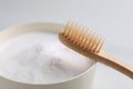 Bamboo toothbrush and bowl of baking soda on white background, closeup Royalty Free Stock Photo