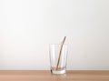 Bamboo toothbrush, glass of water, white a cotton towel and powder for brushing your teeth in jar. light gray concrete