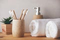 Bamboo toothbrushes in a cup and white towels