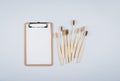 Bamboo toothbrushes and empty notepad blank for text on grey background. Zero waste, mockup concept Royalty Free Stock Photo