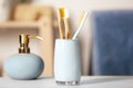 Bamboo toothbrushes in holder on light table indoors Royalty Free Stock Photo