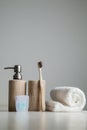 Bamboo toothbrushes, toothpaste, white towel on the gray table.