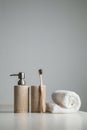 Bamboo toothbrushes, toothpaste, white towel on the gray table.