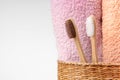 Bamboo toothbrushes with towels in a wicker wooden basket with copy space on white background. Spa, healthy lifestyle and ecology Royalty Free Stock Photo