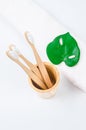 Bamboo toothbrushes in wooden glass with towel