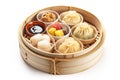 a bamboo tray holds food that contains various sauces and dumplings