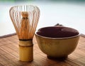 A bamboo whisk resting next to a ceramic tea bowl Royalty Free Stock Photo