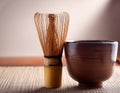 A bamboo whisk resting next to a ceramic tea bowl Royalty Free Stock Photo