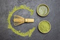 Bamboo whisk on the table. Green matcha tea powder and matcha tea in green bowls