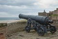 Old Iron Cannon at Bamburgh Castle on Northumberland Coast of England, UK Royalty Free Stock Photo