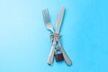 Ban on food as diet for weight loss. The fork and knife are wrapped in a chain and locked against blue background.