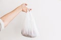 Ban single use plastic. Woman holding in hand groceries in plastic polyethylene bag. Zero Waste shopping concept. Reuse, reduce,