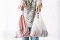 Ban single use plastic. Zero Waste shopping concept. Woman holding in one hand groceries in reusable eco bag and in other