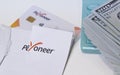 Ban on using a Payoneer card in Russia, sanctions. Payoneer card with calculator and dollars on a white table.