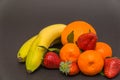 banana, apple, orange,strawberries and Three tangerine with leaves on a beautiful gray background, beautiful colors and compositi