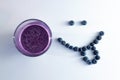 banana and blueberry smoothie in a glass cup with a smiling face of blueberries Royalty Free Stock Photo