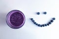 banana and blueberry smoothie in a glass cup with a smiling face of blueberries Royalty Free Stock Photo