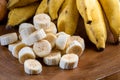 Banana bunch, sliced bananas in bowl and on wooden board