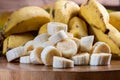 Banana bunch, sliced bananas in bowl and on wooden board