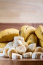 Banana bunch, sliced bananas in bowl and on wooden board