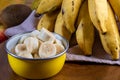 Banana bunch, sliced bananas in bowl and on wooden board