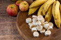 Banana bunch, sliced bananas in bowl and on wooden board