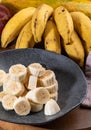 Banana bunch, sliced bananas in bowl and on wooden board