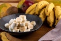 Banana bunch, sliced bananas in bowl and on wooden board