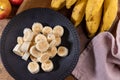 Banana bunch, sliced bananas in bowl and on wooden board