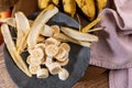 Banana bunch, sliced bananas in bowl and on wooden board