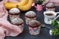 Banana-chocolate muffins in paper forms against a dark background