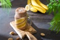 Banana chocolate smoothie, milkshake in a glass jar and fresh banana on dark background. Healthy organic drink. Side view, copy Royalty Free Stock Photo