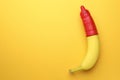 Banana with condom on orange background, top view and space for text. Safe sex concept Royalty Free Stock Photo