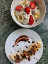 Banana with dark chocolate, muesli and nuts and bowl of yoghurt, banana, strawberries and chia seeds