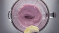 Banana falling berry smoothie in blender close up. Natural ingredients for drink