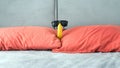 Banana with glasses in the apartment on the bed in the bedroom, red pillows,funny banana with glasses. Royalty Free Stock Photo