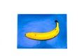 Banana, juice with straw on a blue background. The straw lies on a blue background in the form of a sail and waves