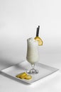 Banana milkshake in glass on a white plate with pieces of banana Royalty Free Stock Photo