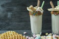 Banana milkshake with ice cream and whipped cream, marshmallows, cookies, waffles, served in a glass cup decorated with Royalty Free Stock Photo