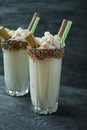 Banana milkshake with ice cream and whipped cream, marshmallows, cookies, waffles, served in a glass cup decorated with Royalty Free Stock Photo