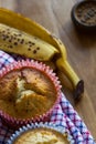 Banana muffins, banana skin, cloth and weight on wood background