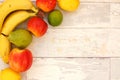 Banana, pear, lime, apples and lemons in the corner on the wooden background