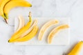 Banana Peel and Bananas on White Marble Board