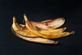 Banana peel on a black background. A bunch of overripe banana close-up