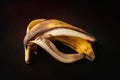 Banana peel. Peel of one overripe banana on a dark abstract background close up