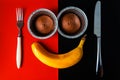 Banana smiley face with chokolate cupcakes and yellow banana. Flat lay of face made from fruit and bake