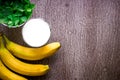 Banana smoothie and fresh banana on wooden table. Royalty Free Stock Photo