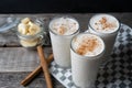 Banana smothie or milkshake with cinnamon on wood background