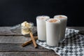 Banana smothie or milkshake with cinnamon on wood background